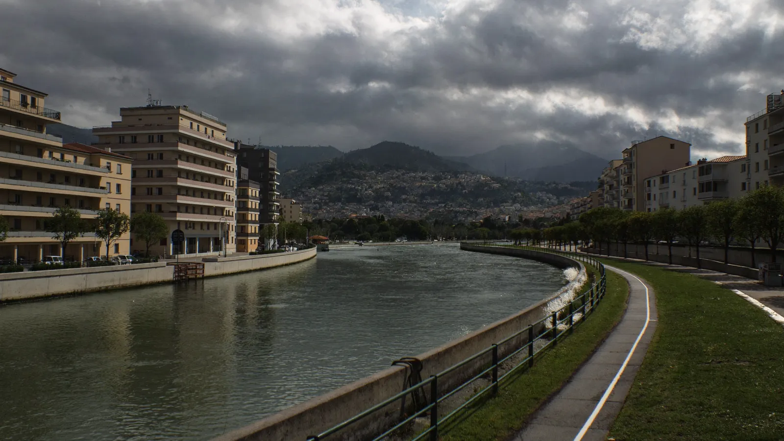 Lit canalisé du Paillon à Nice un jour de crue, immeubles pastel autour
